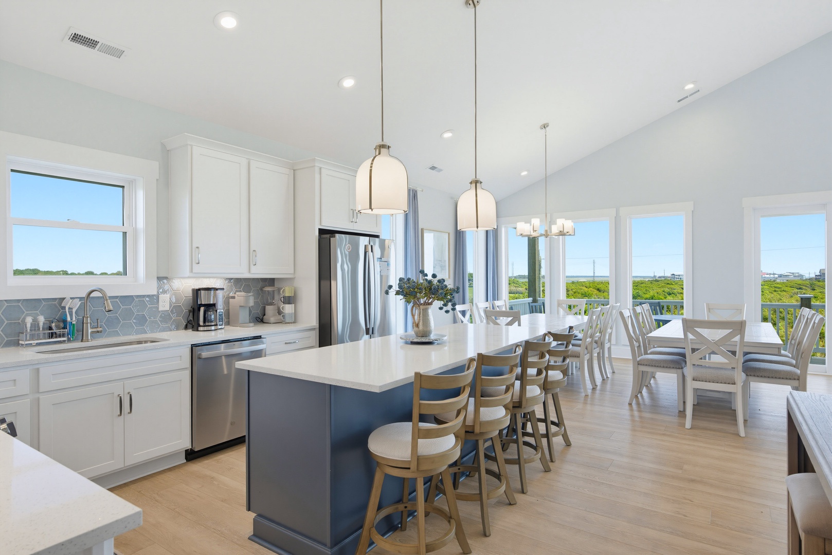 Gather around the kitchen island with your group as natural light fills this open-concept space, or settle in at the dining table where lush green marsh views stretch across the horizon through wide windows.