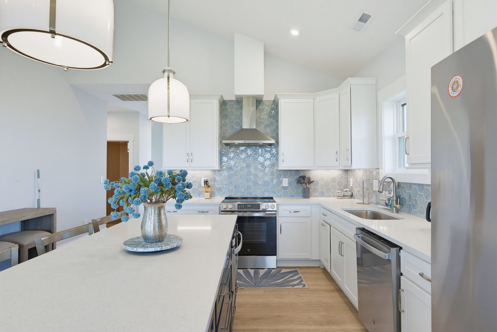 Prepare your favorite meals in a bright, modern kitchen featuring stainless steel appliances, elegant hexagon backsplash, and plenty of counter space for cooking and entertaining.