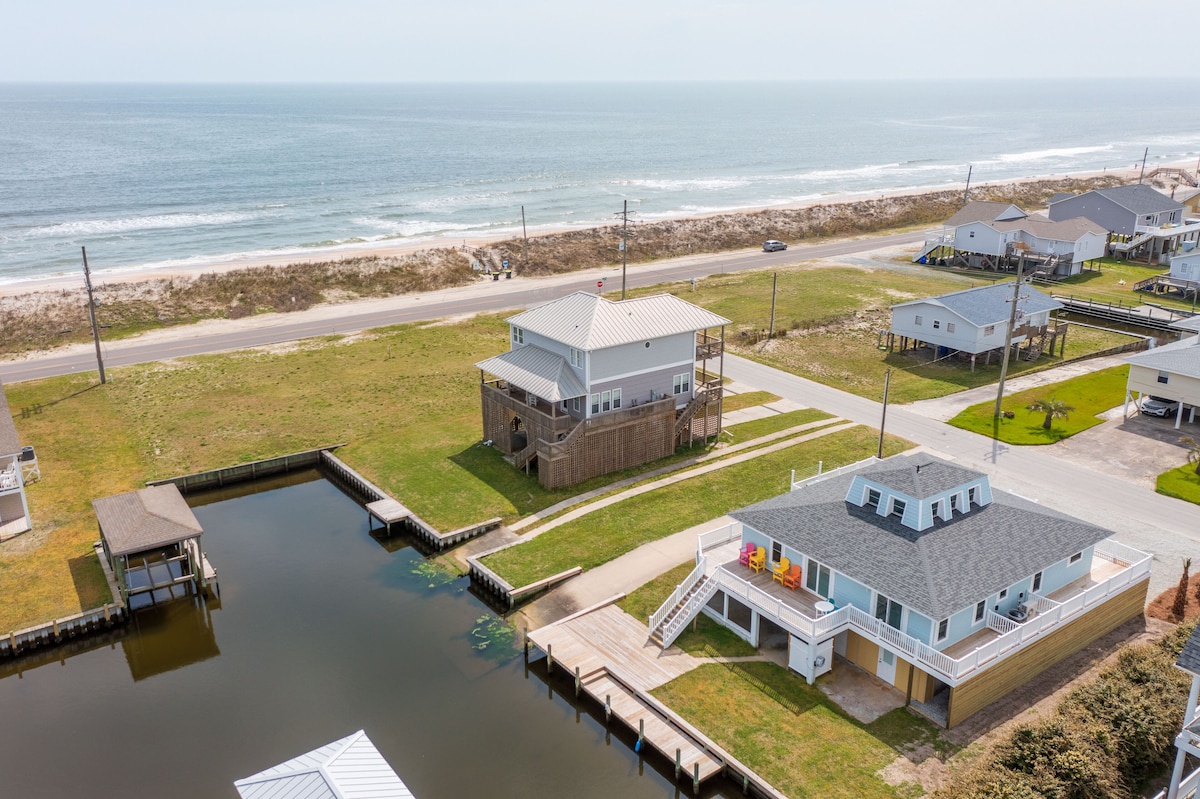 A coastal property with a dock, a small boat, and a beach view.
