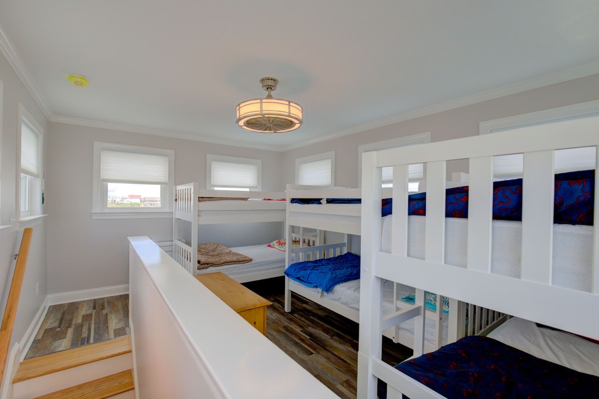 Open children's sleeping loft with three twin bunk beds; this area is not enclosed and is not a private room.