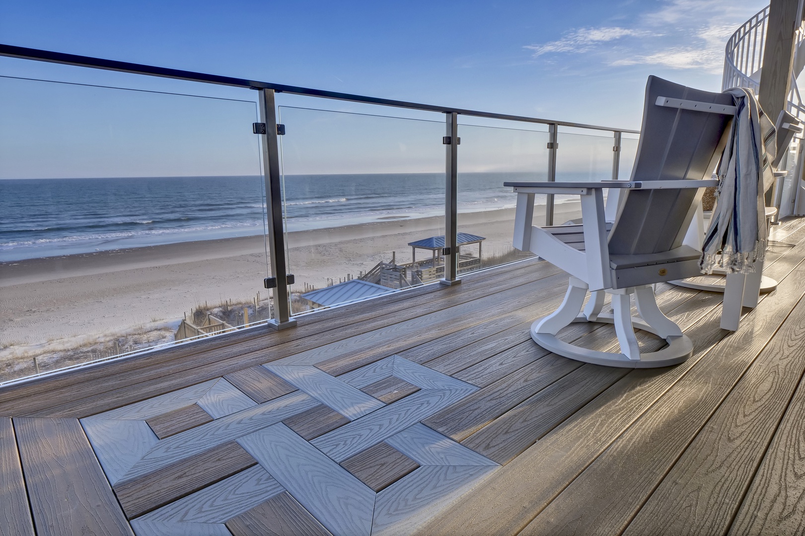A beachfront balcony positioned directly on the sandy shore, offering expansive coastal views and a peaceful setting for watching the waves roll in each morning.
