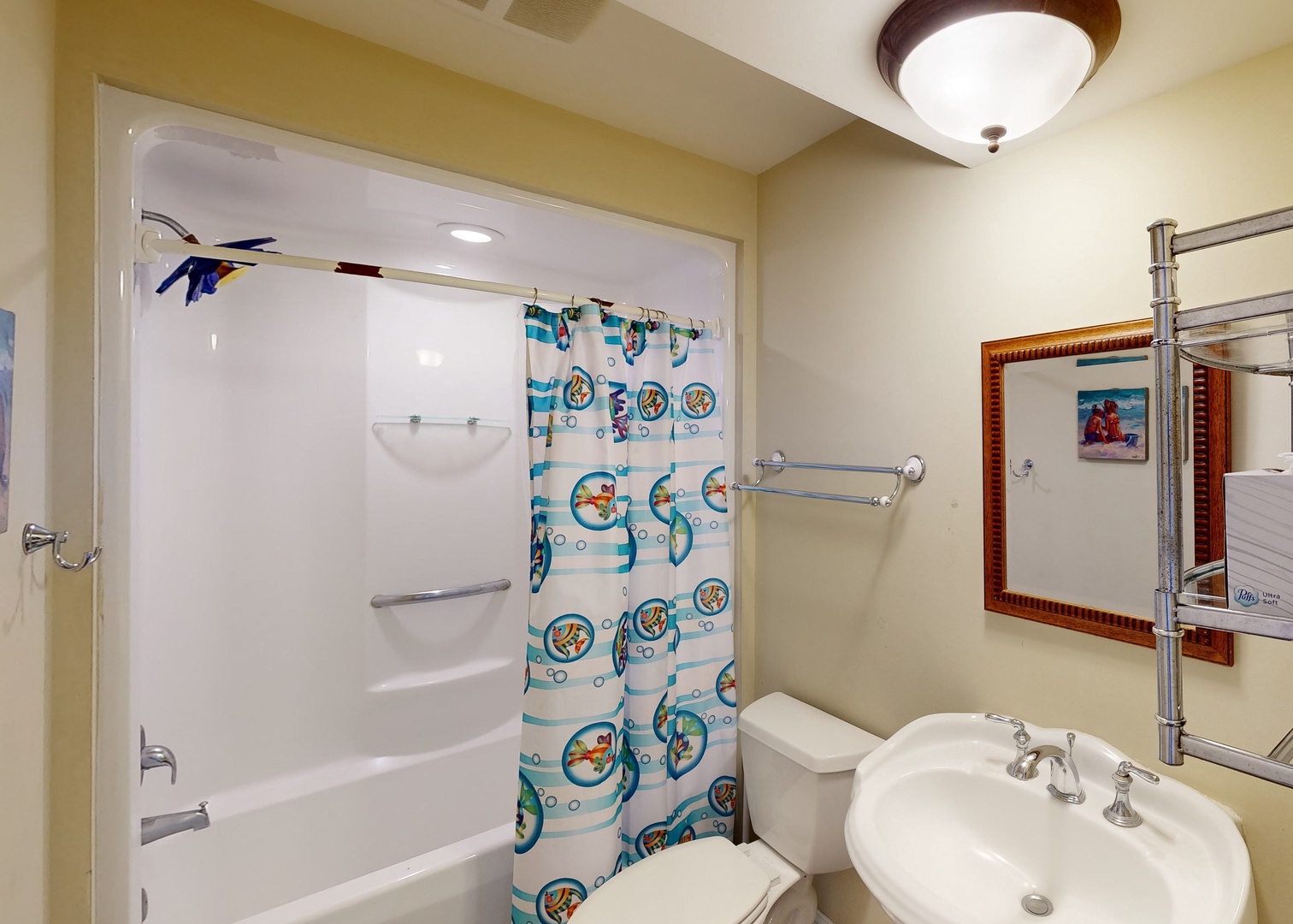 Freshen up in your well-lit bathroom, complete with a full tub-shower combo and cheerful beach-themed curtain—perfect for unwinding after a day of adventure.