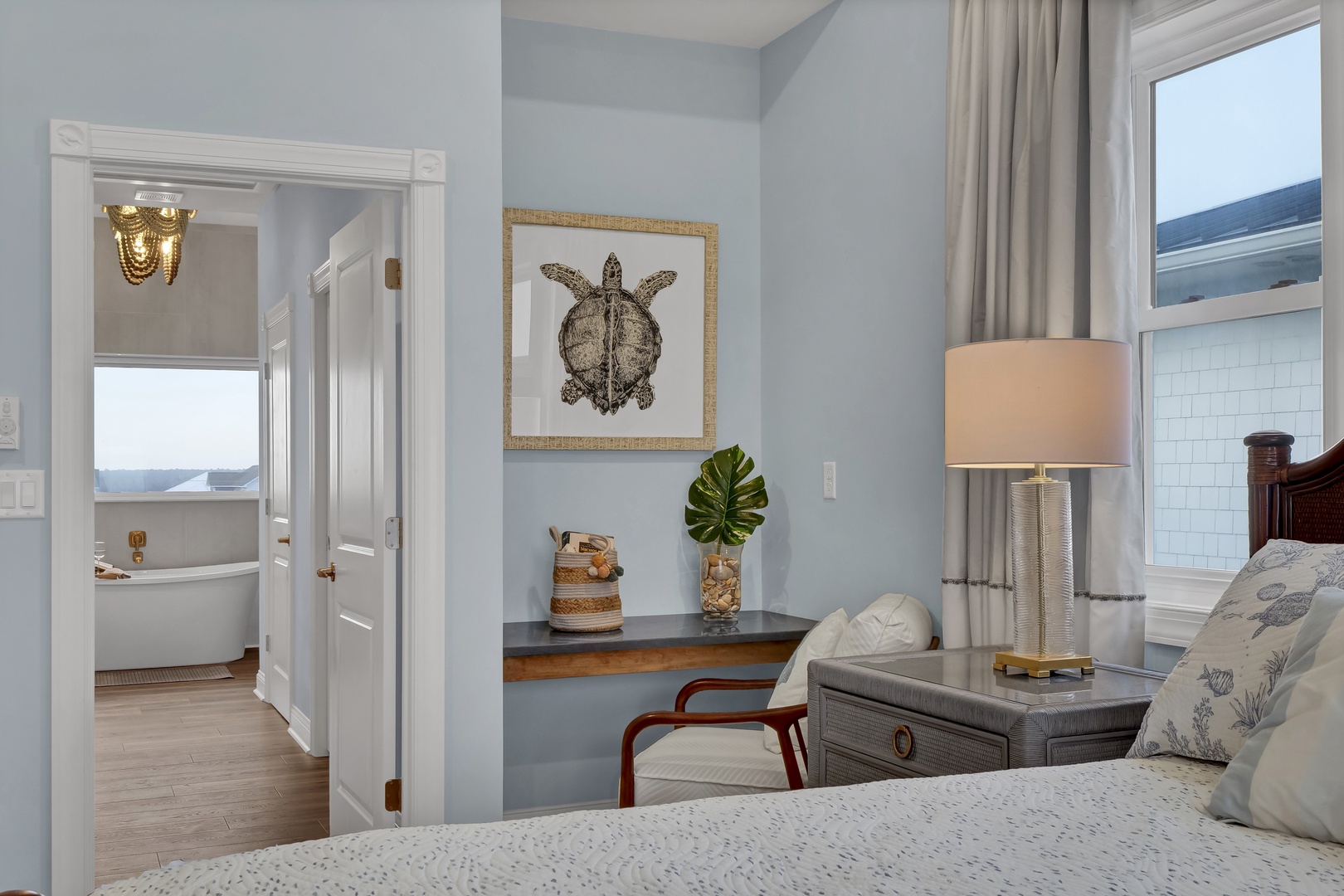Relax in your coastal-inspired bedroom with soft blue walls and warm wood accents. Your private desk overlooks the property, and the ensuite bath invites you to unwind in comfort.