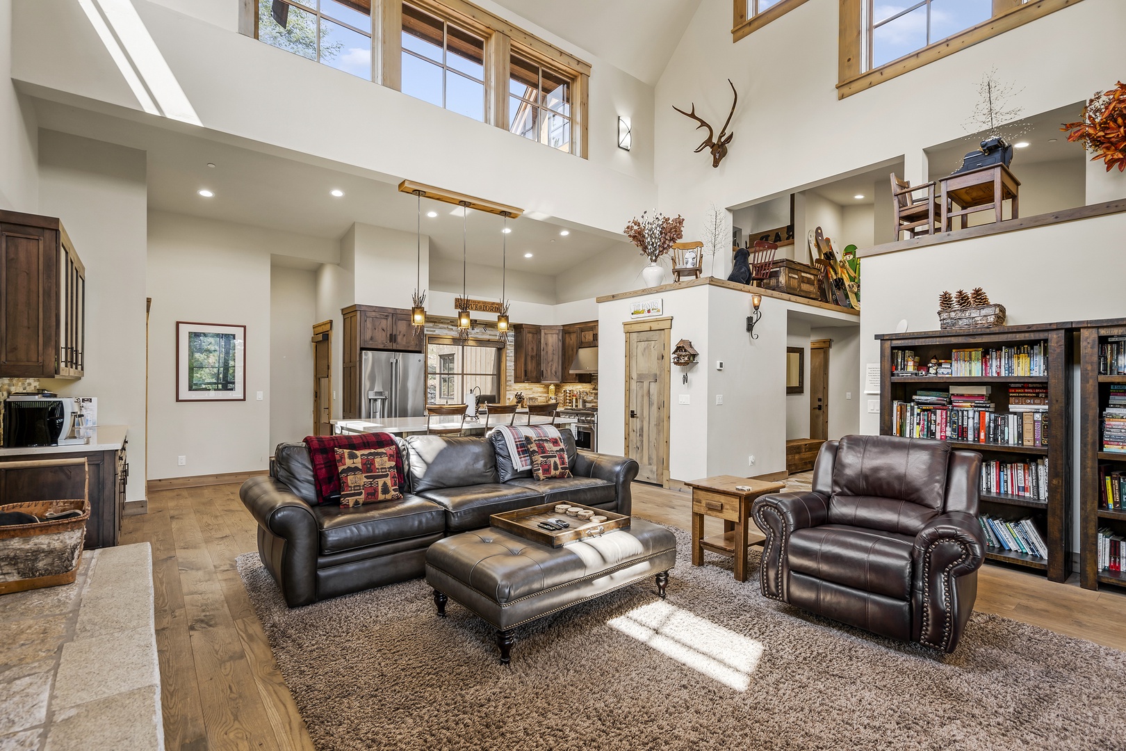 Main Floor living room with comfortable leather furniture and  large stone fireplace.