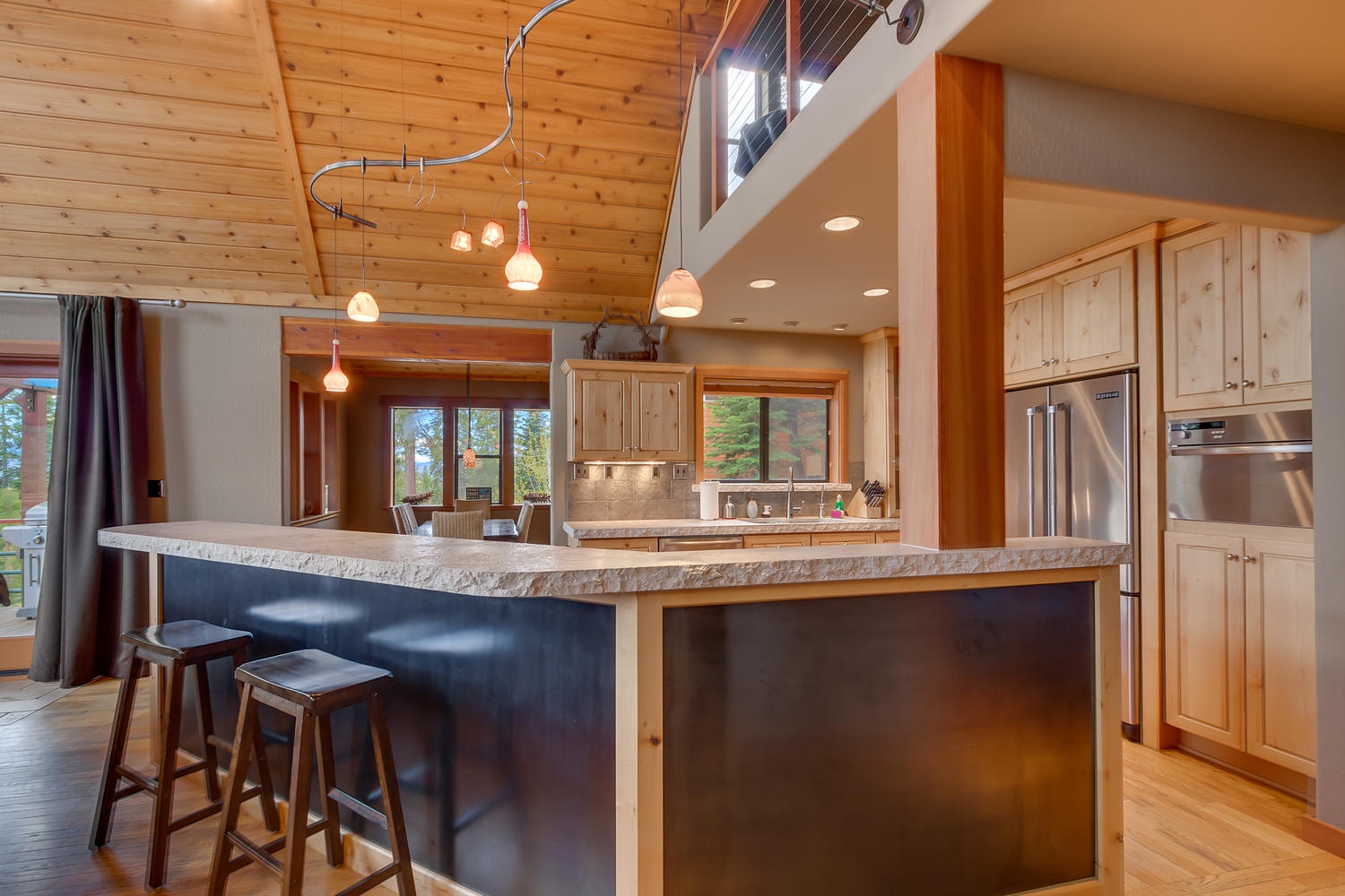 Kitchen with refrigerator and bar style seating: Falcon's Eye View Retreat