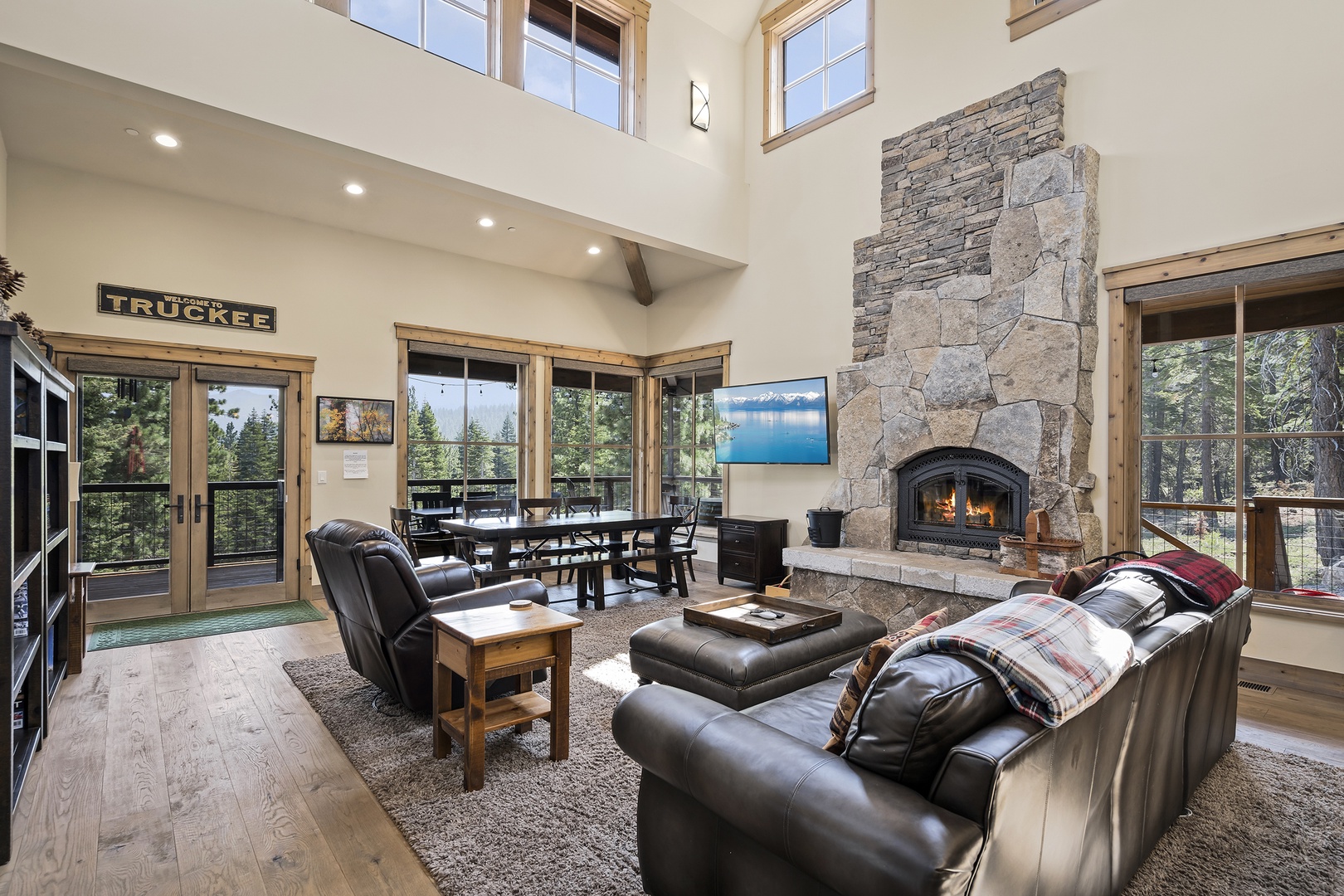 Main Floor living room with comfortable leather furniture and  large stone fireplace.