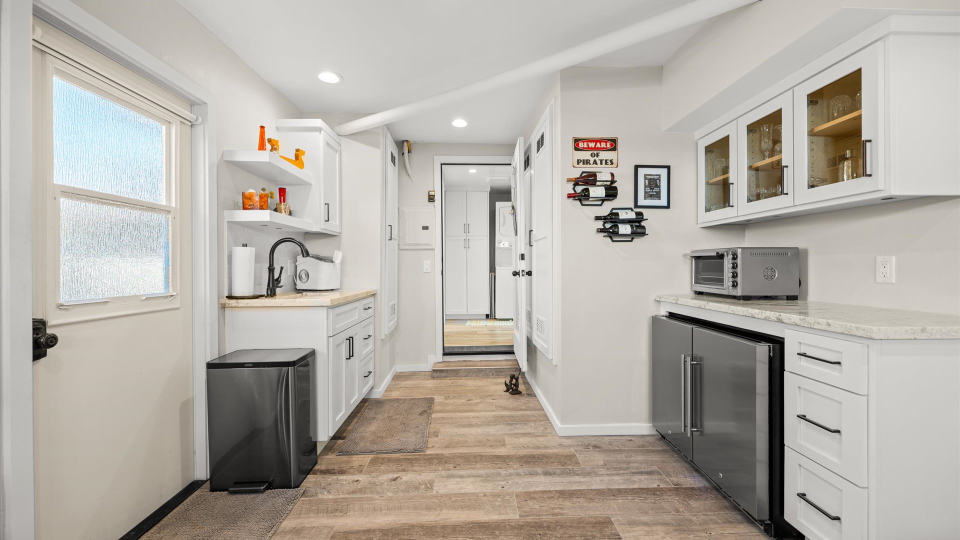 Lounge space also includes a small kitchenette area with wine fridge, sink, and toaster oven