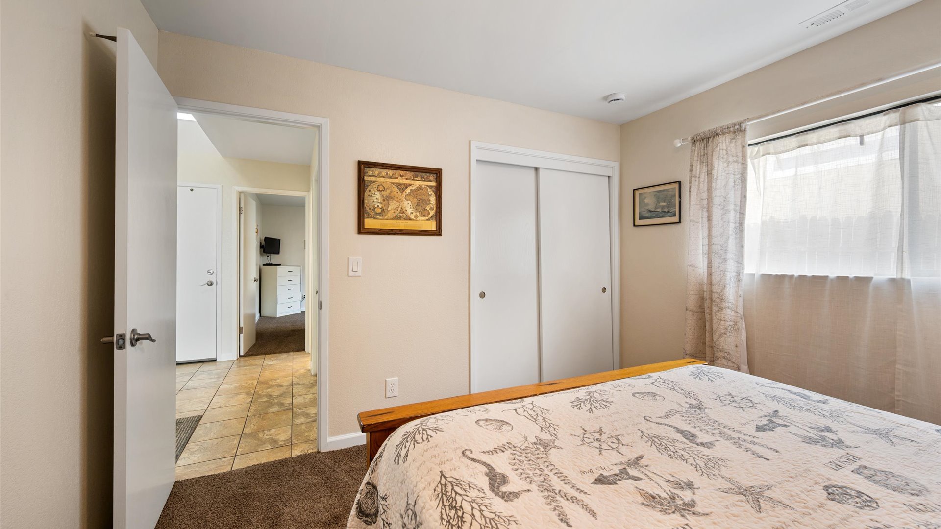The second bedroom has warm wood accents with nautical decor