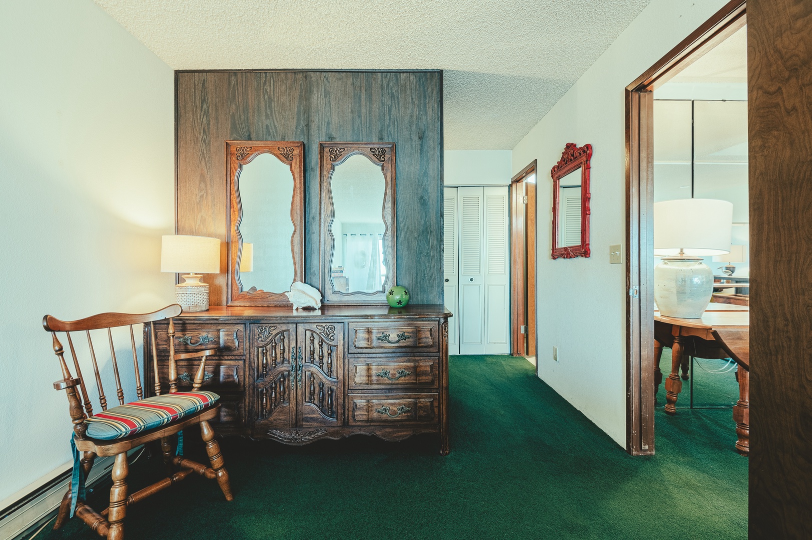 The charming master bedroom with vintage wooden furnishings, ornate mirrors, and cozy seating that creates a warm, homey atmosphere.