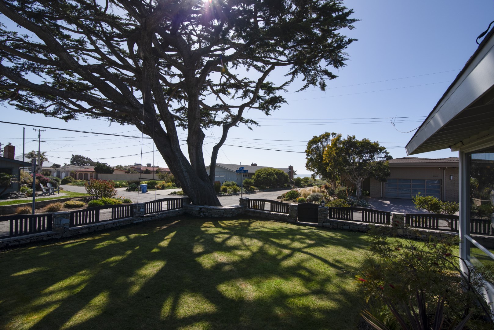 Imagine relaxing in this yard shaded by the Cypress tree, the ocean just steps away