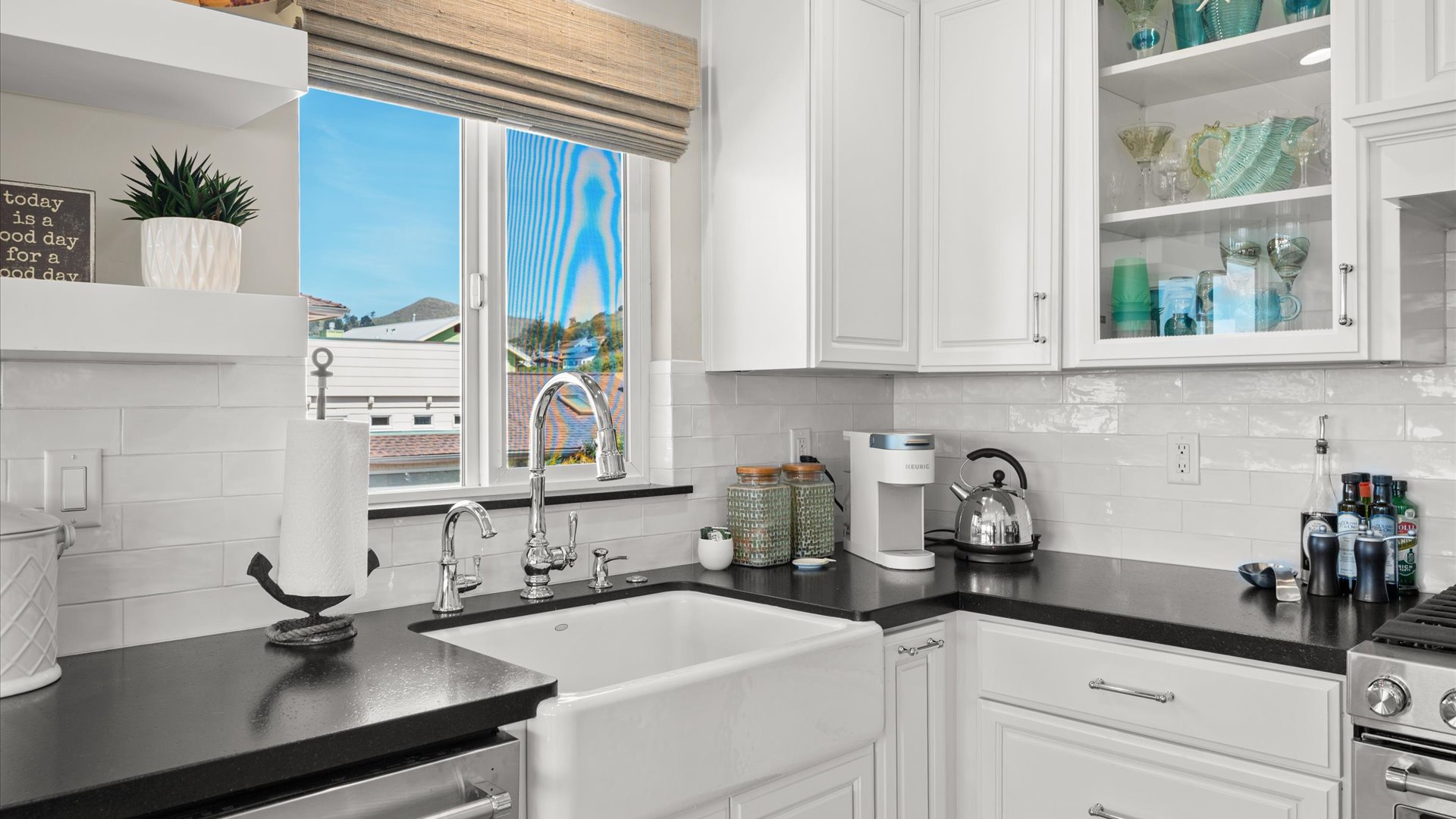 The kitchen features a charming farmhouse sink and whimsical coastal touches