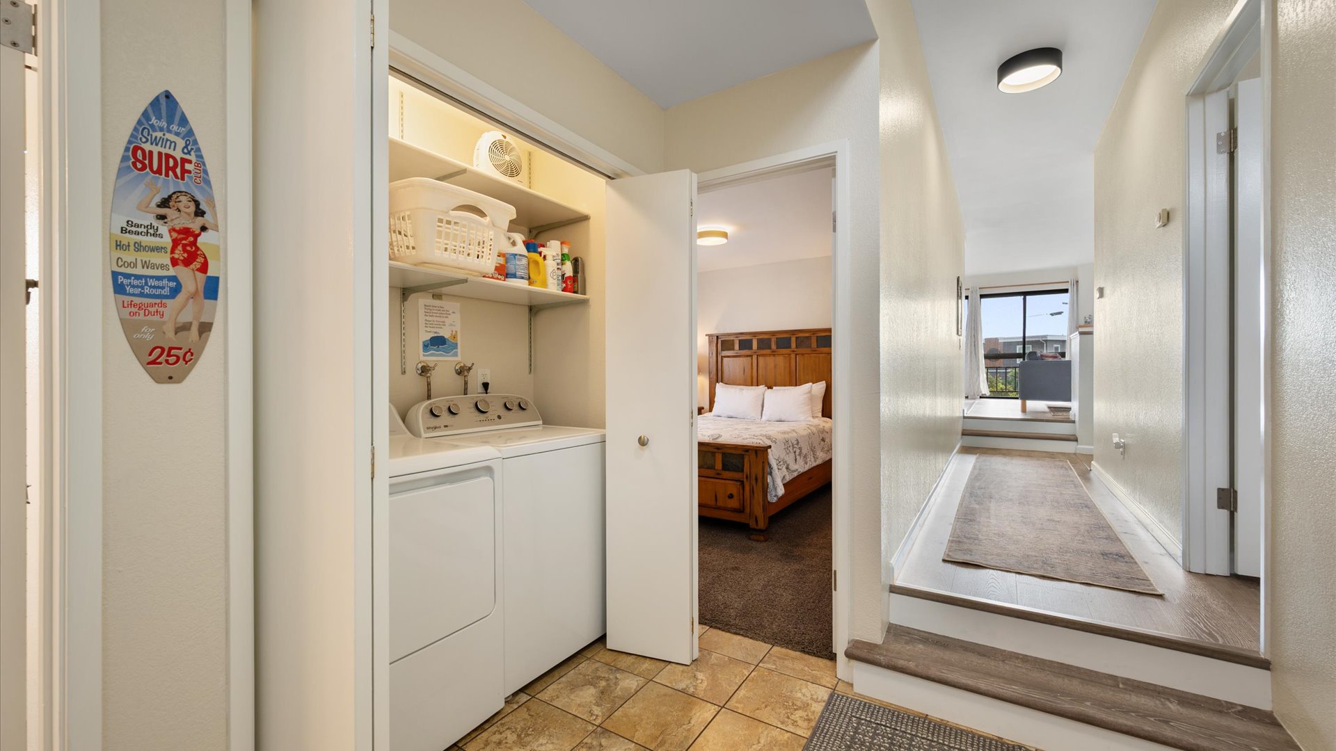 hallway between the living area and bedrooms, features laundry closet with washer and dryer