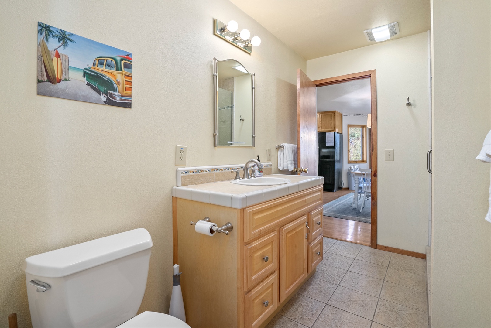 Main level bathroom with flow through access from the kitchen and the entry hallway.