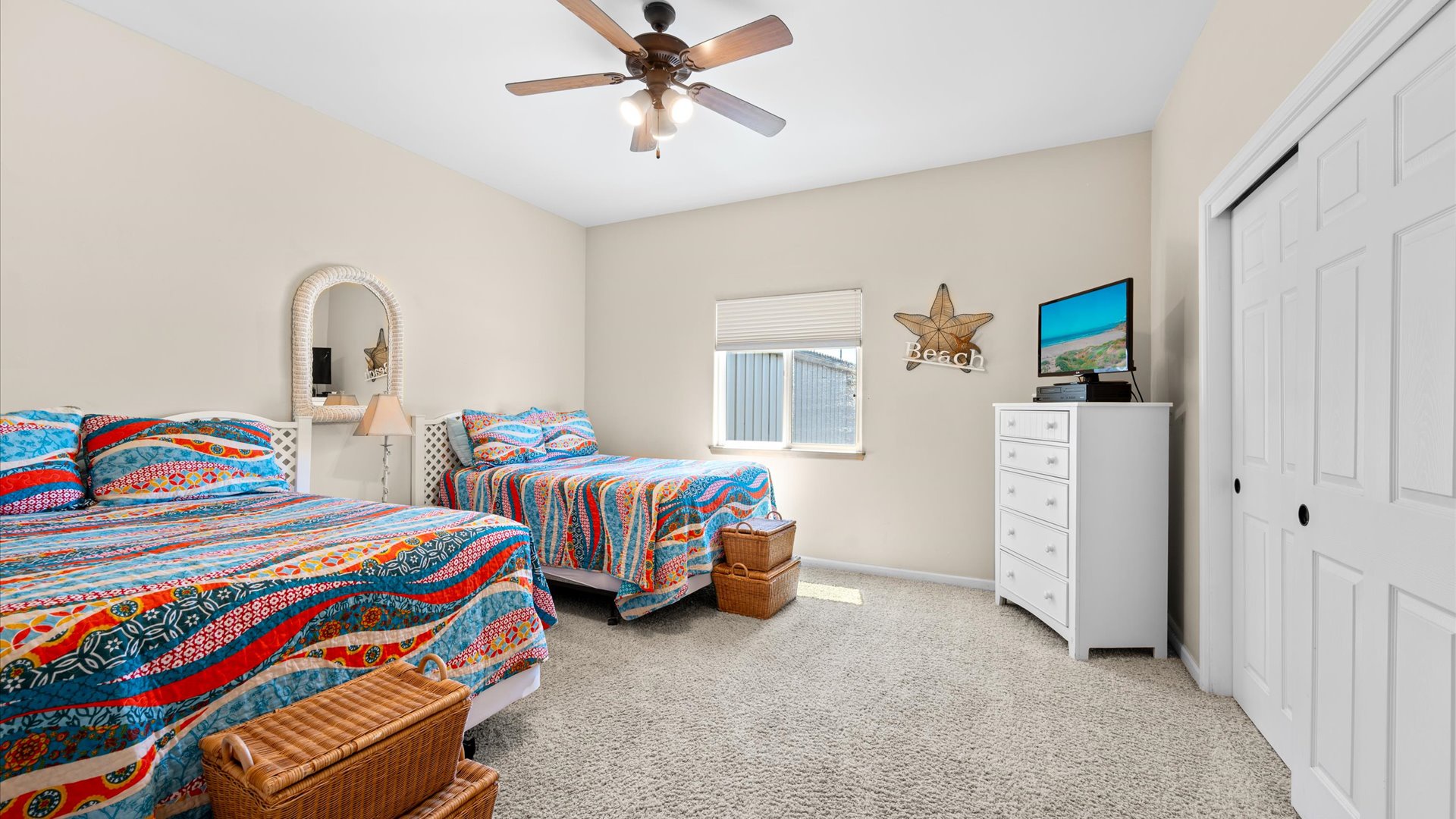 The second bedroom features 2 full sized beds and a flat screen tv