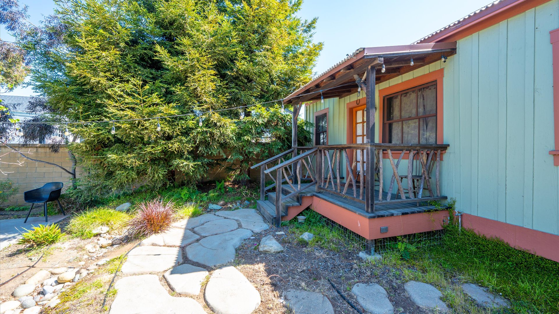 The rustic railings and a peaceful garden pathway welcome you to your cozy retreat.