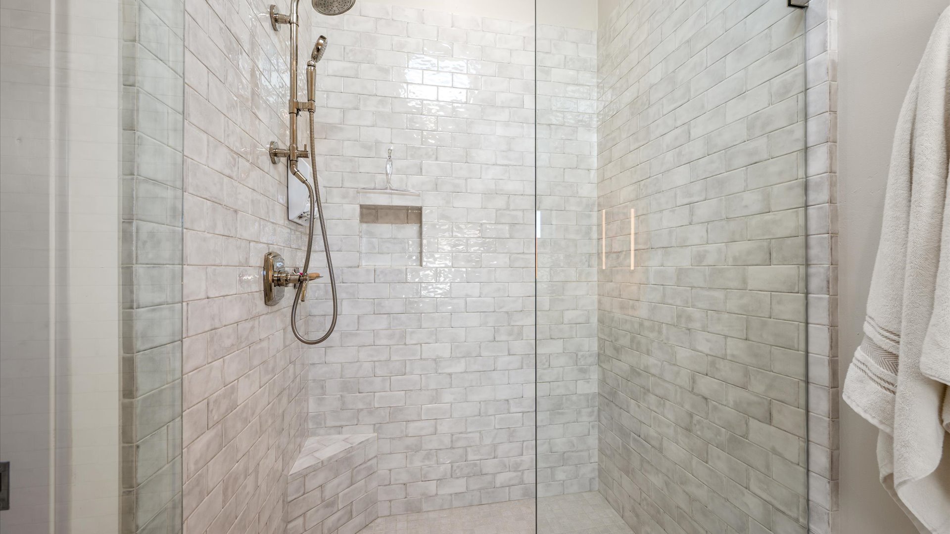 Elegant glass-enclosed shower with beautiful tile walls