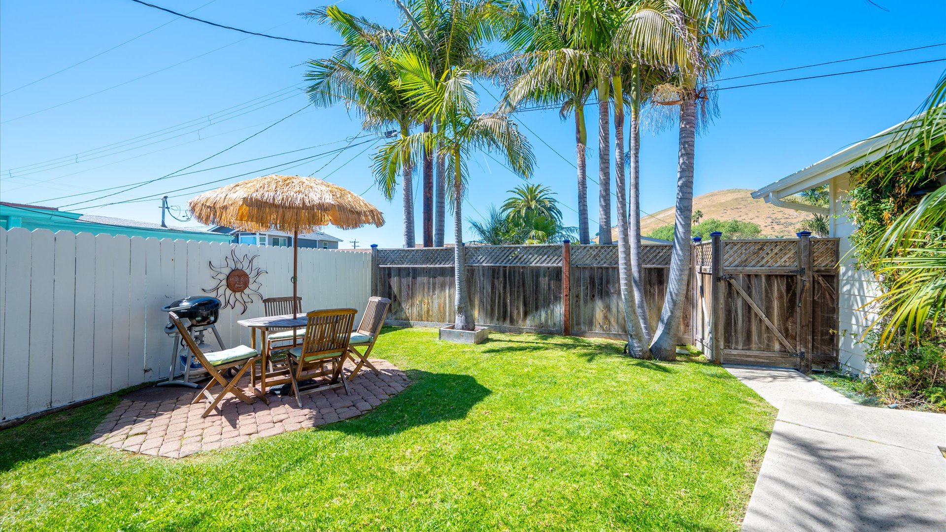 Your private front yard oasis awaits with patio table, BBQ, and palm trees to remind you, the beach is never far away