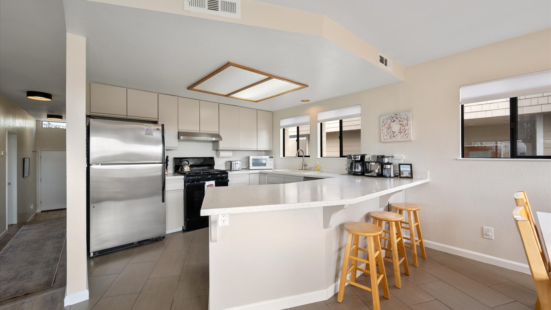 The kitchen awaits with a breakfast bar perfect for morning coffee conversations.