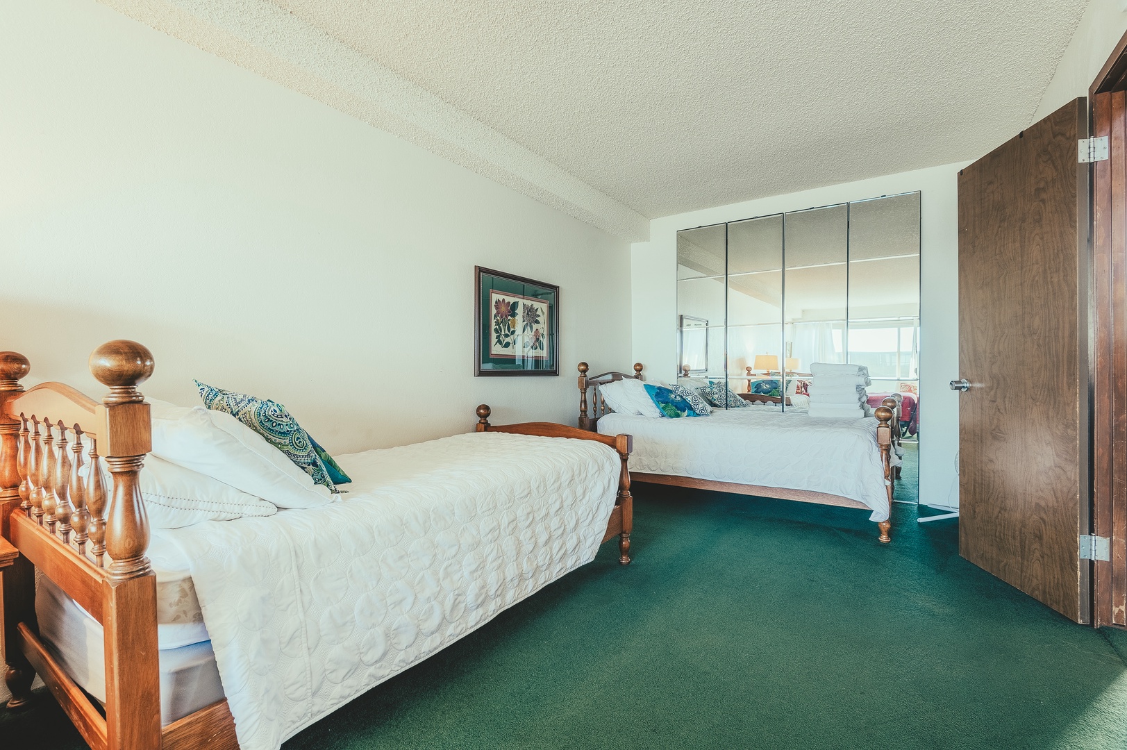 Two twin beds plus a mirrored wall to help amplify the natural light streaming in