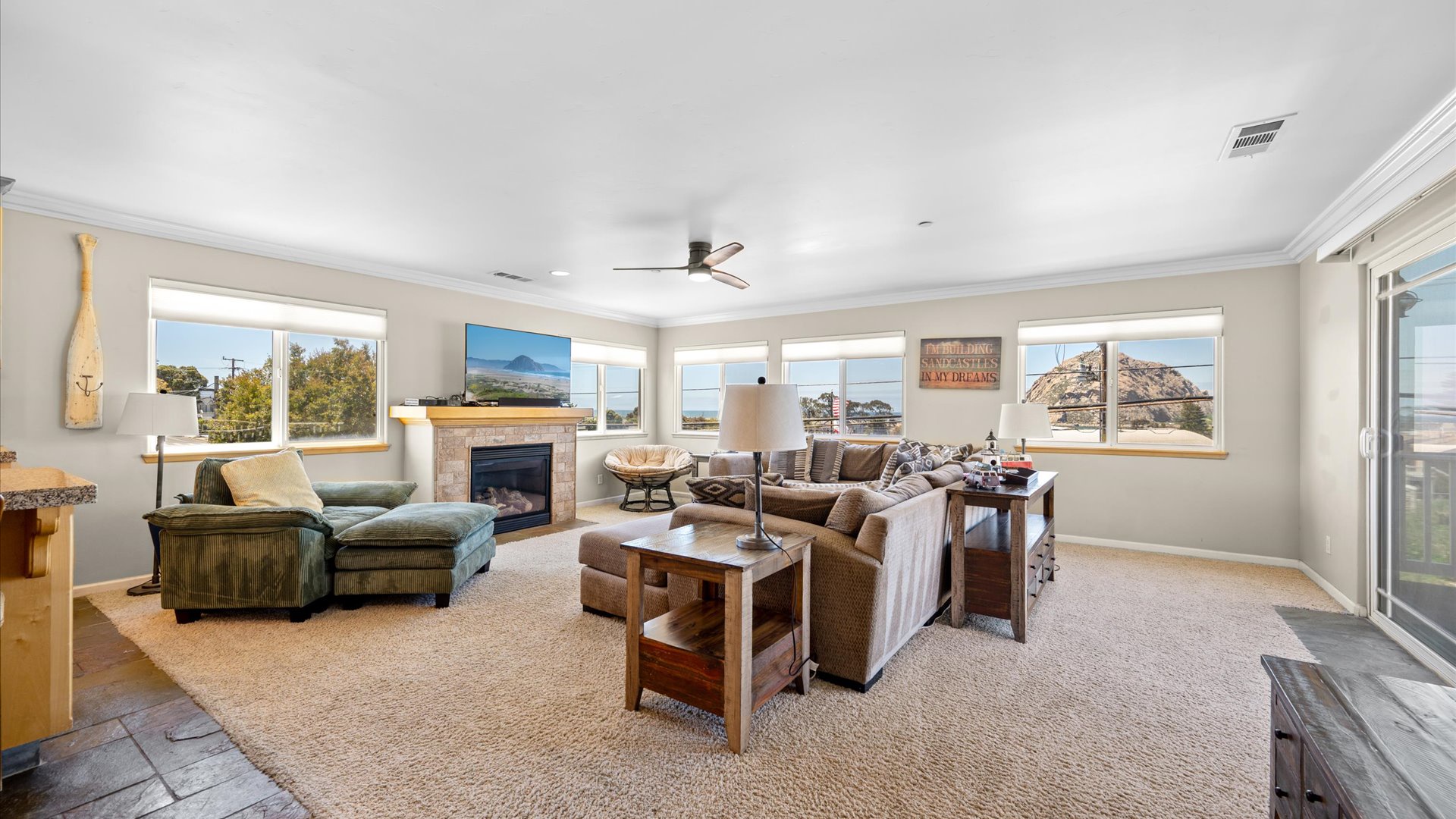 The living room features a fireplace, large flat screen tv, and ample comfortable seating