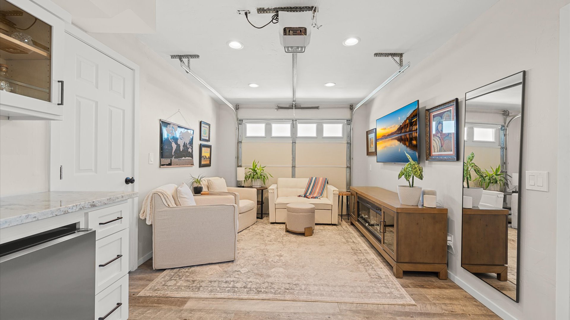 Garage has been converted into a lovely lounge space complete with flat screen tv, fireplace, and comfy seating