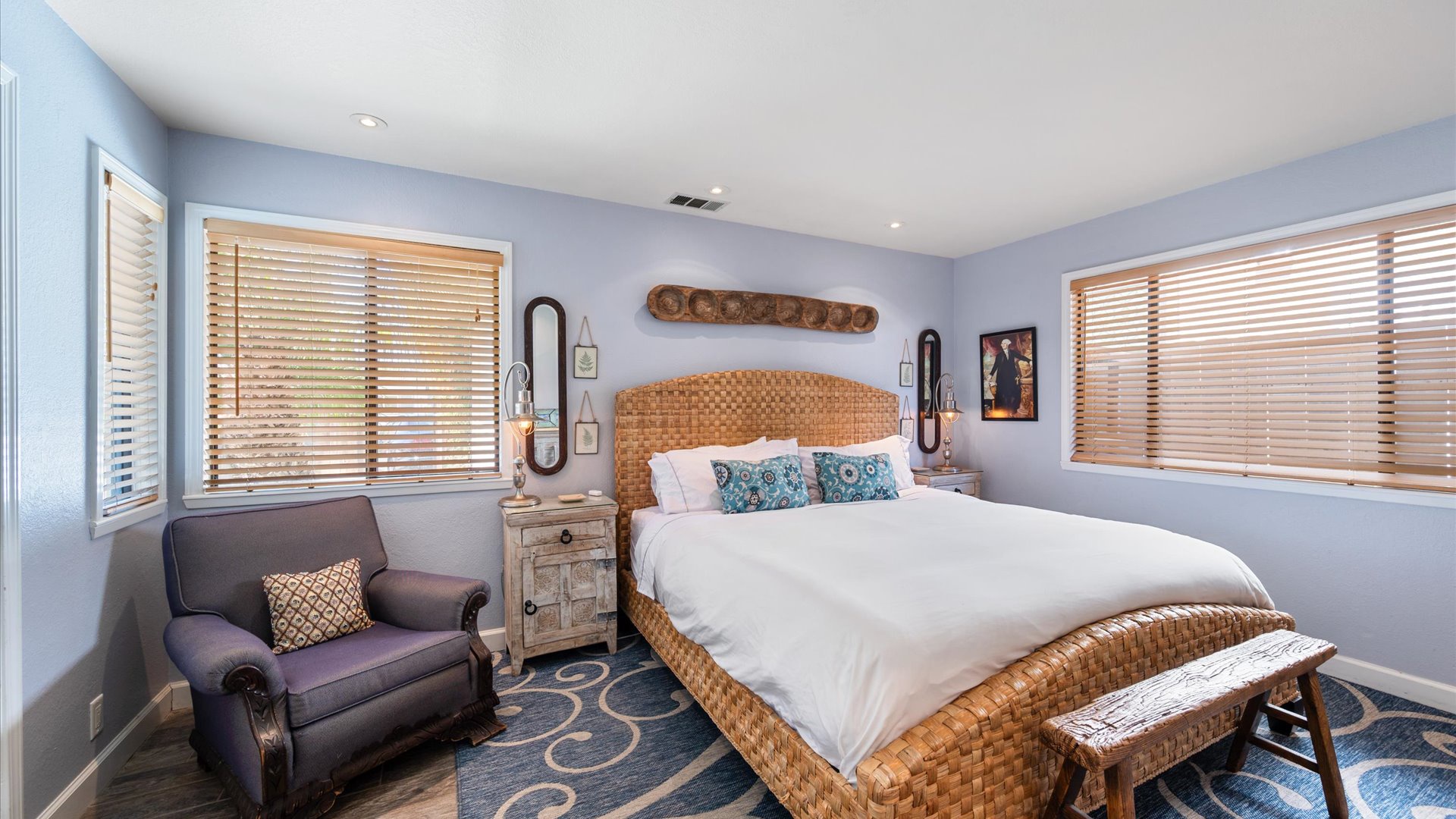 Master bedroom features a king sized bed and coastal touches