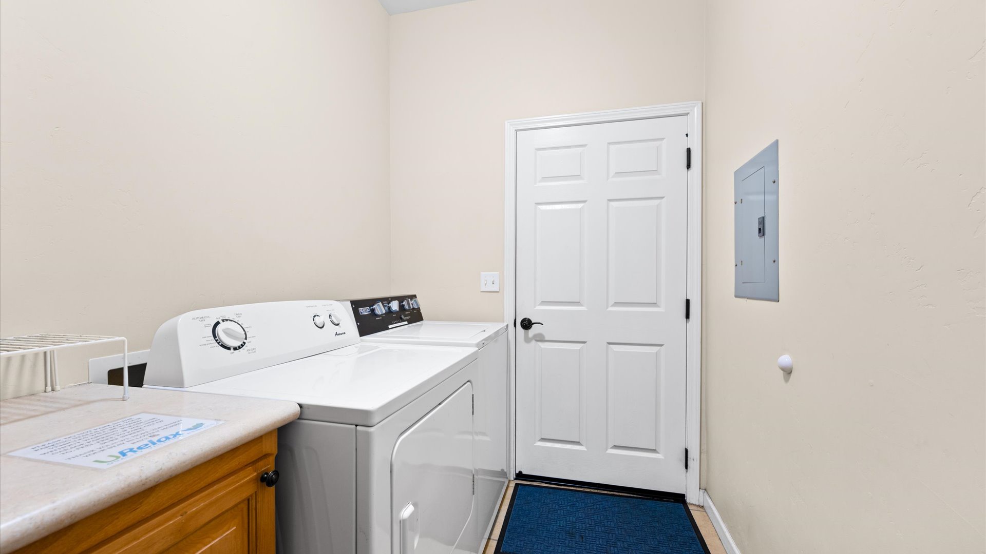 Laundry room downstairs with washer and dryer for guest use, leads to the garage