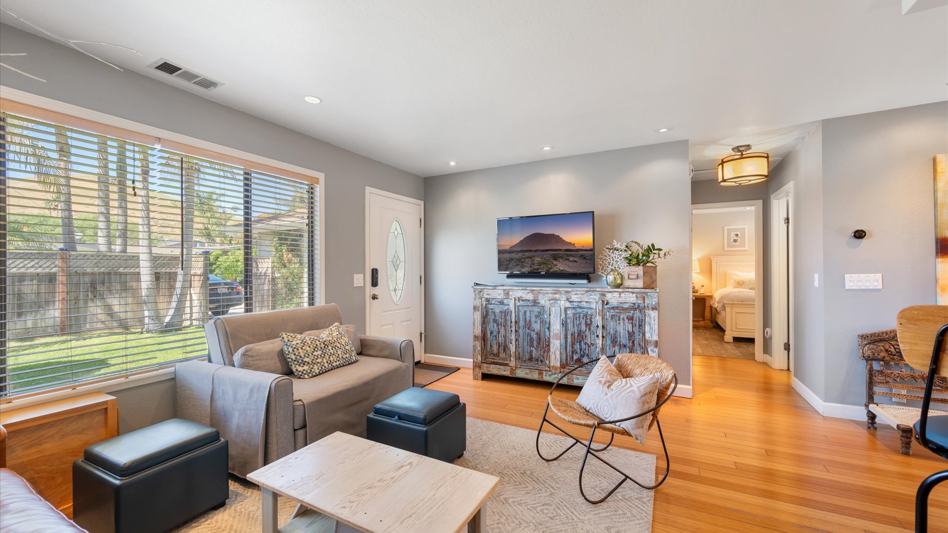 The stylishly furnished living room features a large flat screen TV and the arm chair folds out to a twin sized bed
