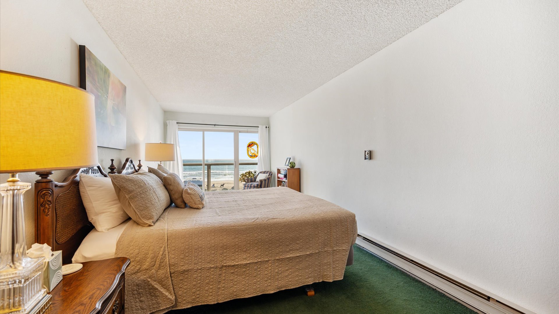 Upstairs primary bedroom features a king sized bed and access to the upstairs balcony