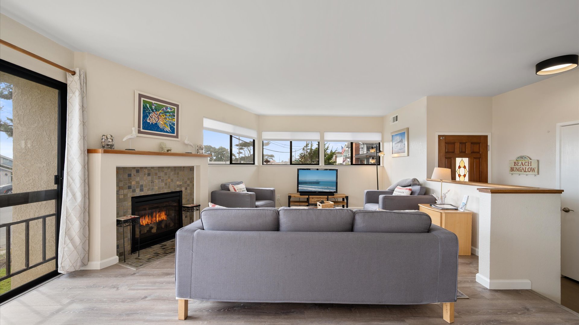 Spacious living room with comfortable seating, cozy fireplace, and flat screen tv