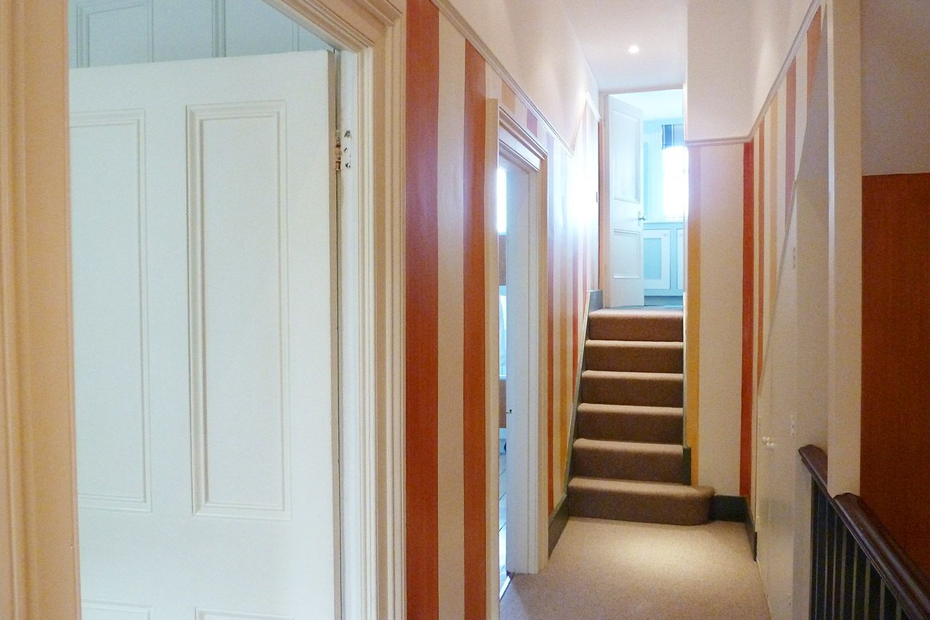 The hallway leading to the bedrooms and third bathroom