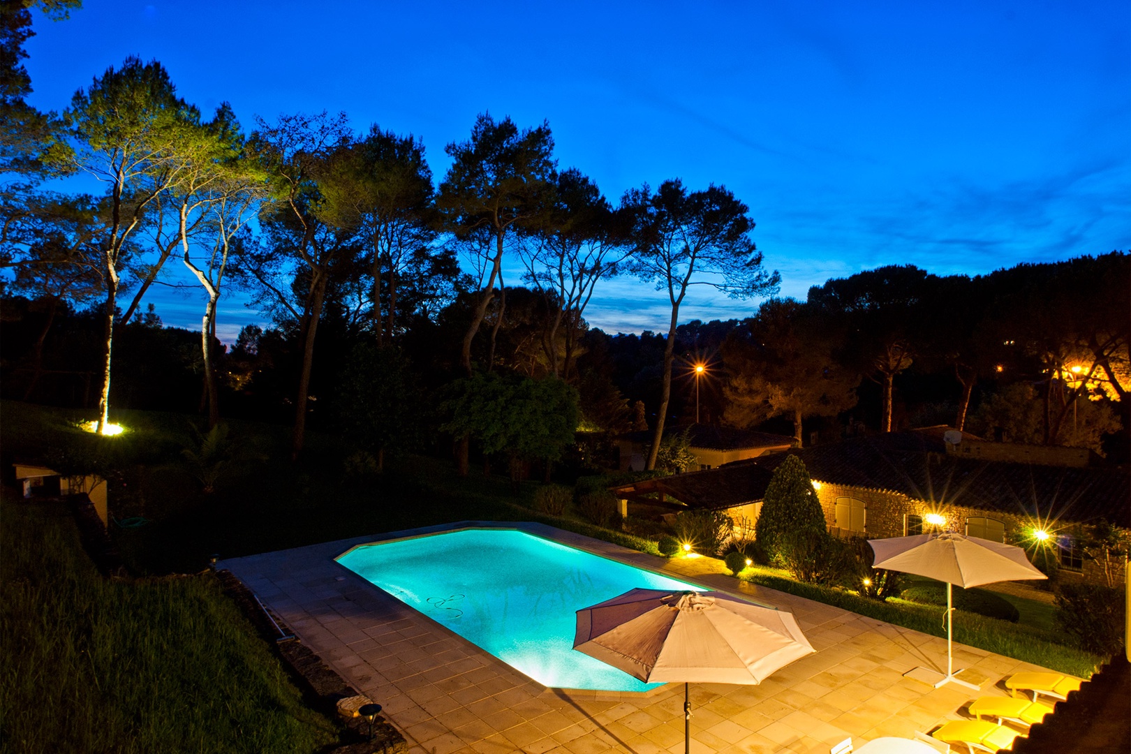 View of the pool at night from the house