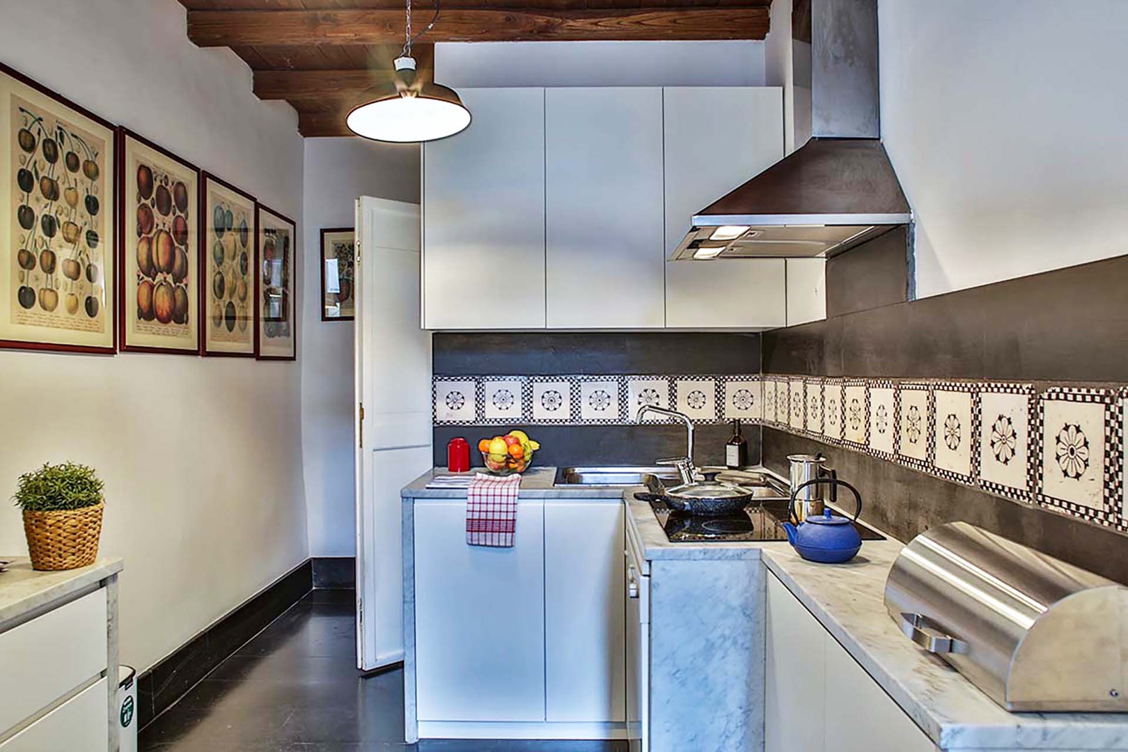 Colorful prints on the first kitchen walls are echoed in the antique Italian tiles that line the walls