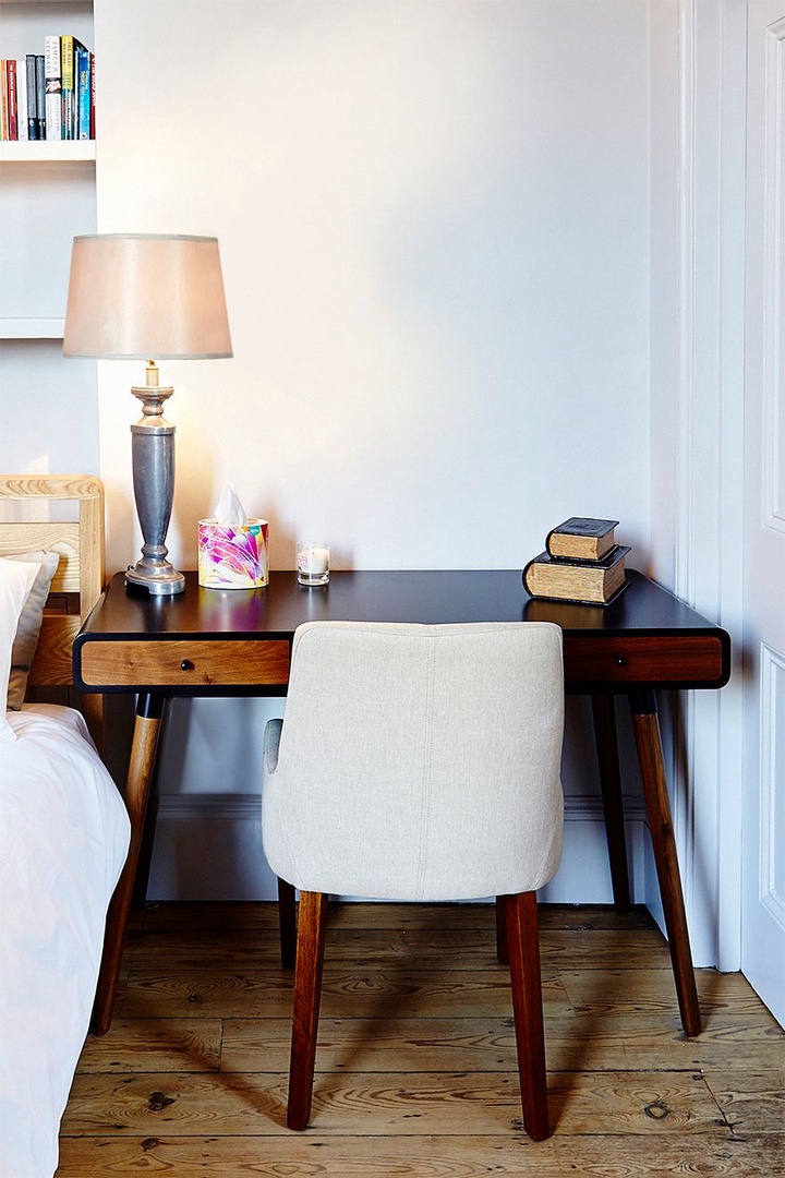 A Charming little desk next to the bed