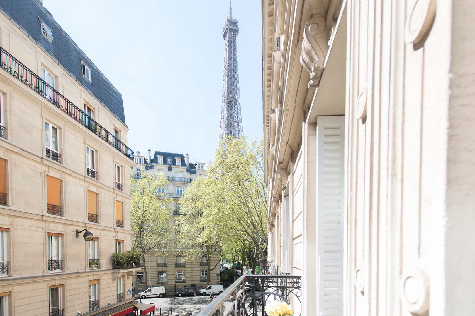The balcony overlooks Paris streets and the beautiful Eiffel Tower.