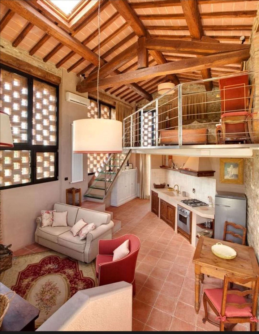 Two-level cottage with living area below and mezzanine bedroom.