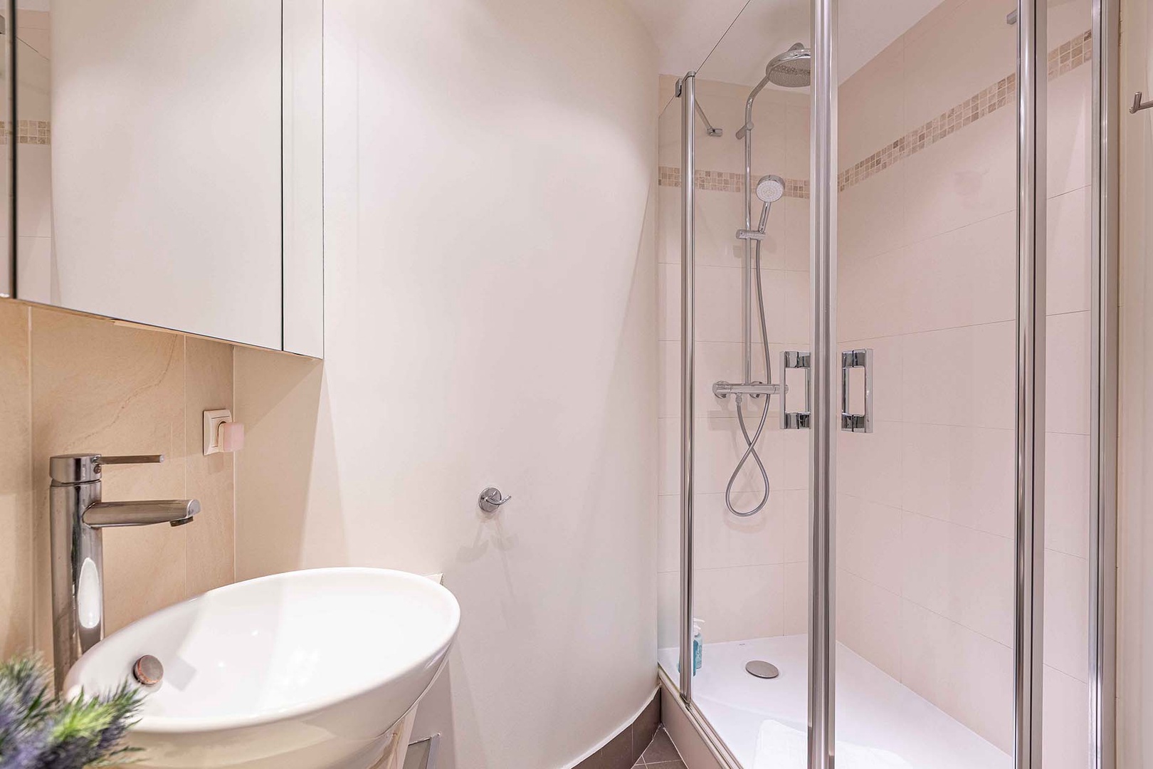 Bathroom has glass enclosed shower.