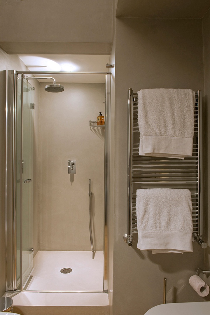 Modern bathroom with large enclosed shower sink and toilet.