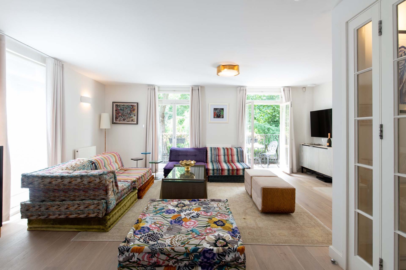 Second level living room has large doors opening to balcony.