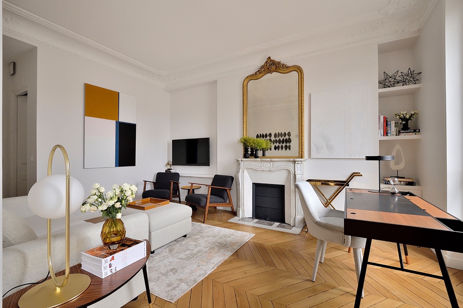 Bright office with sofa, TV and a desk.