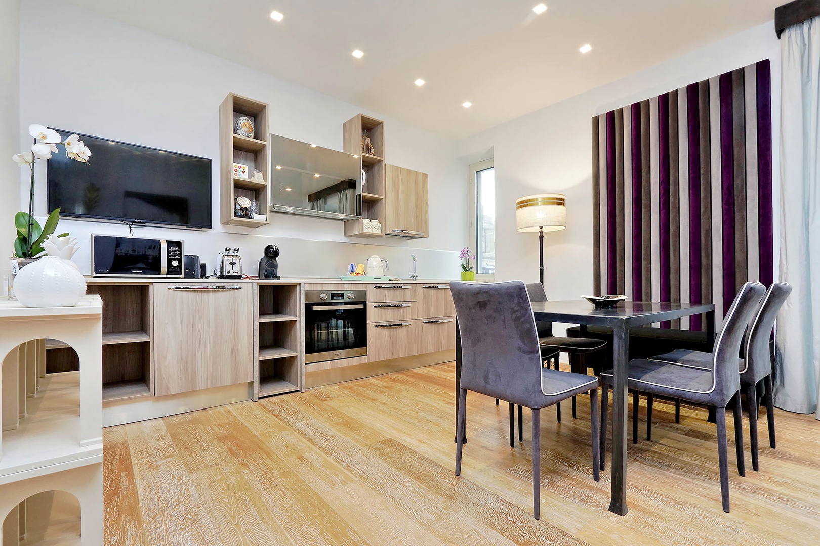 Modern kitchen and large wall-mounted flat screen TV.