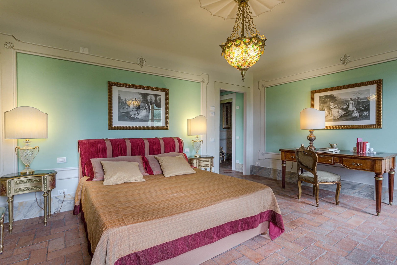 A beautiful chandelier adorns this spacious bedroom