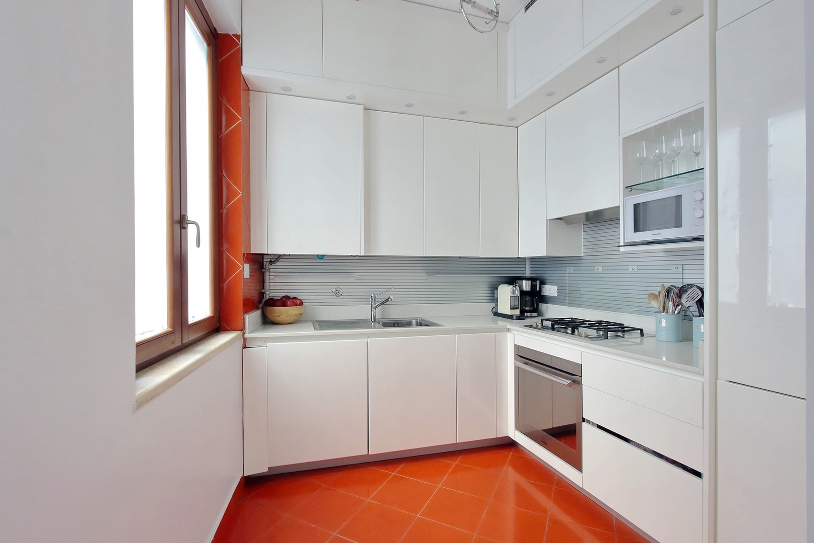 Fully equipped kitchen with modern white cabinets.