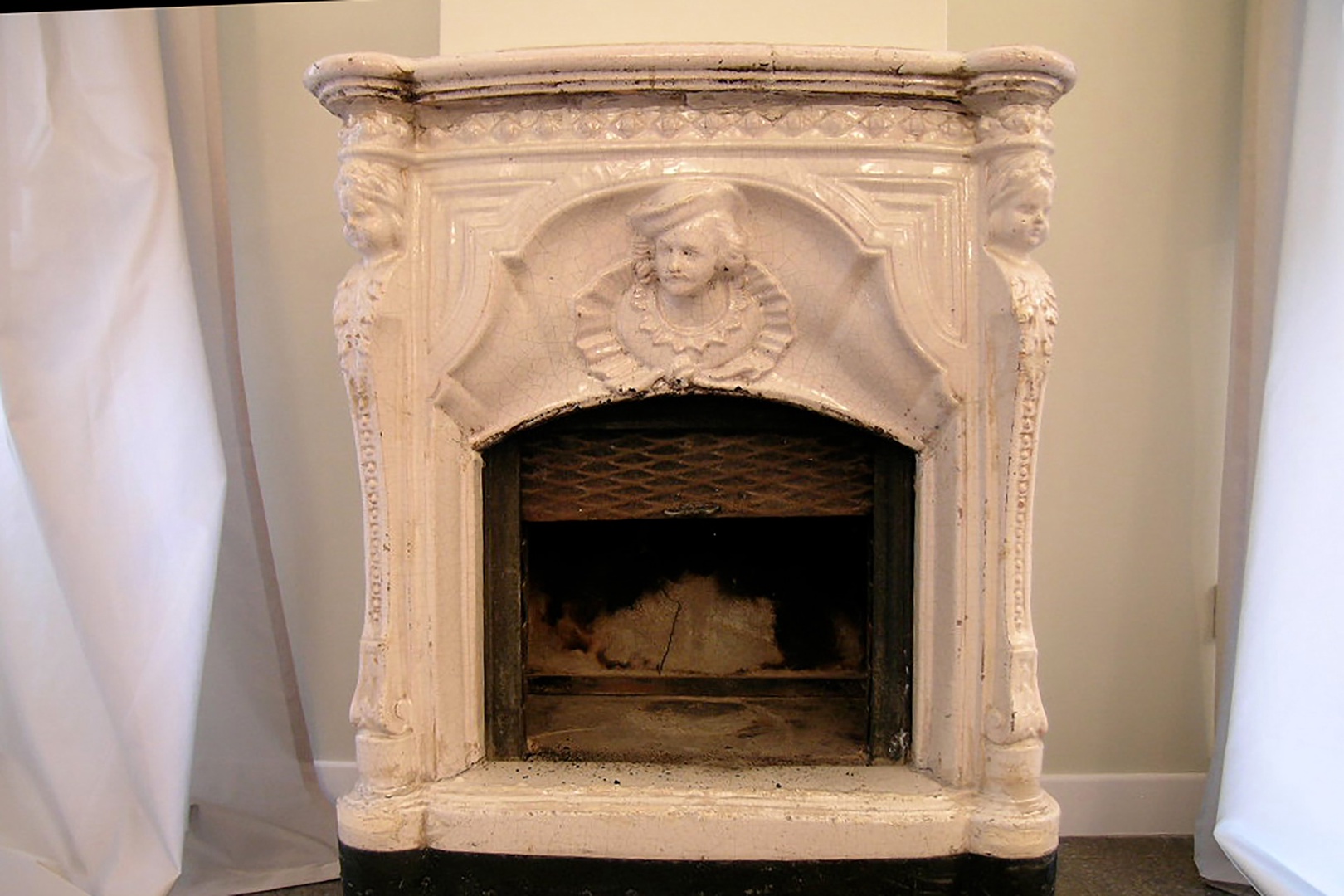 This 200 year old decorative ceramic fireplace originally heated the room.