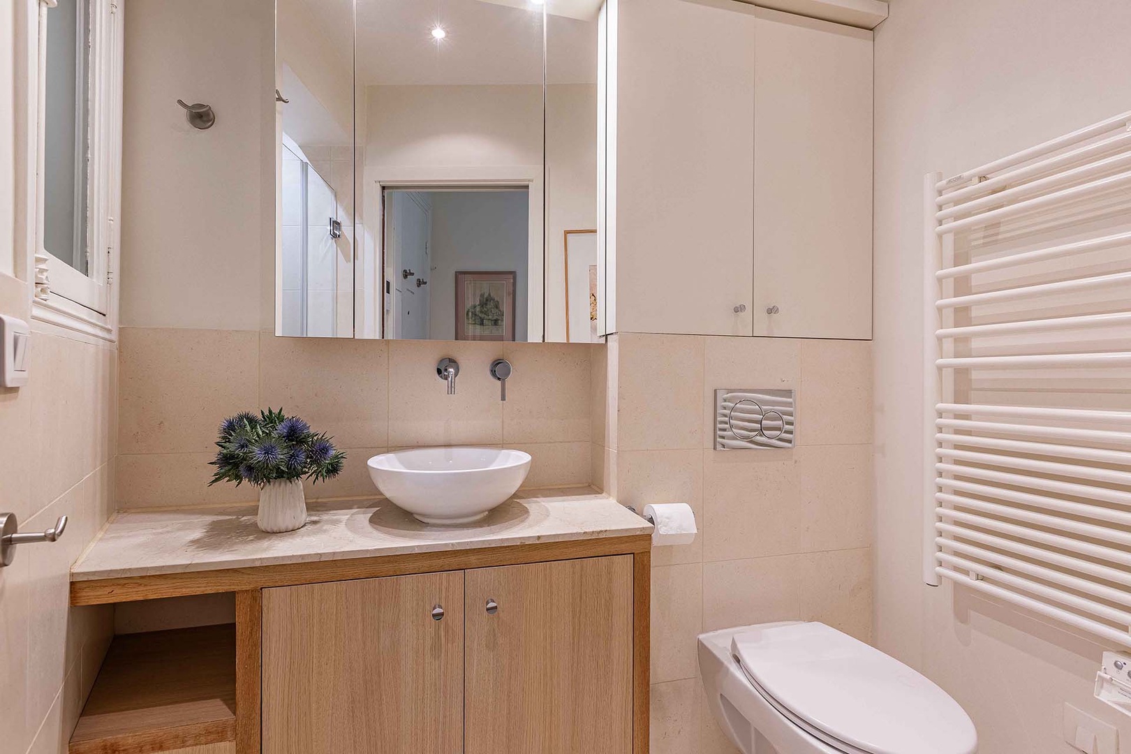 The bathroom blends modern elegance with warm wood tones