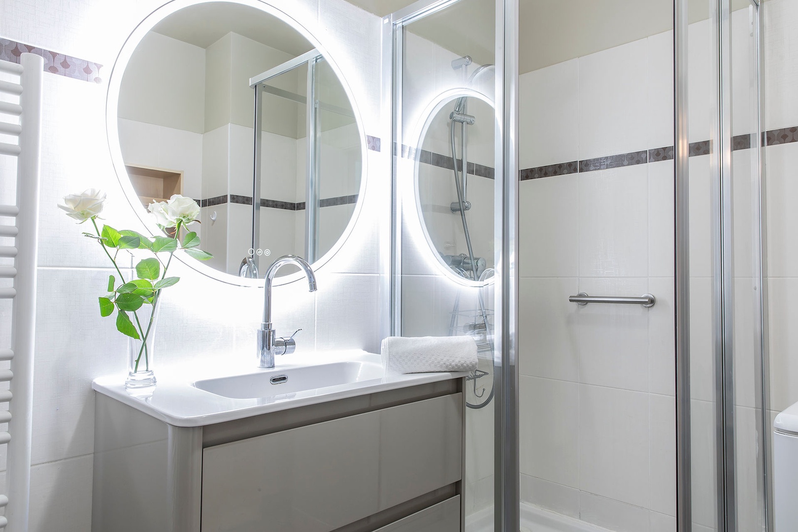 Bathroom with shower, sink and towel rack. Toilet is in the half bath.