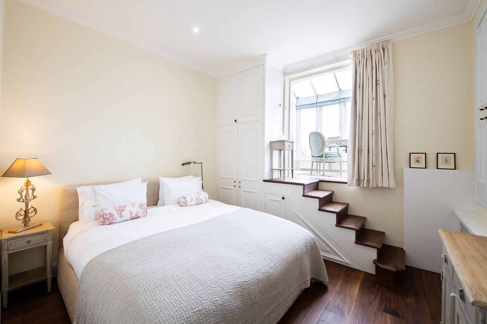 Serene bedroom with steps up to a sunroom.