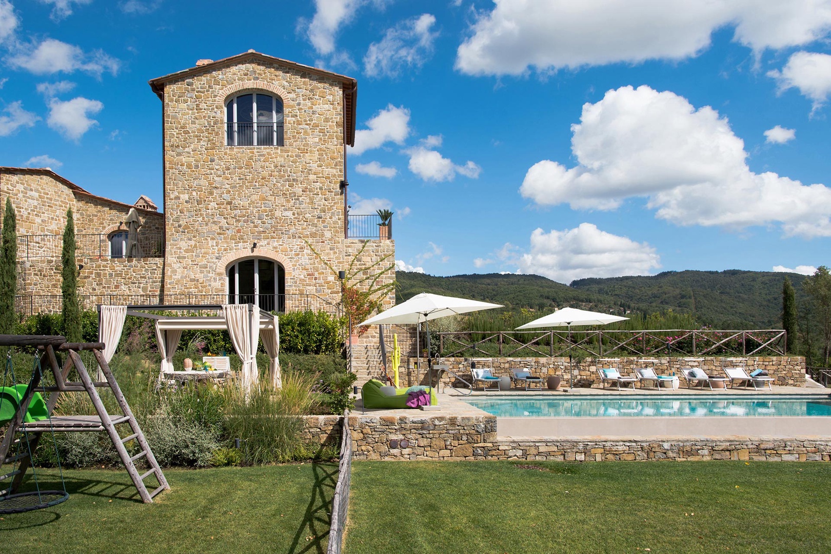 Dine poolside at the large table beneath the pergola