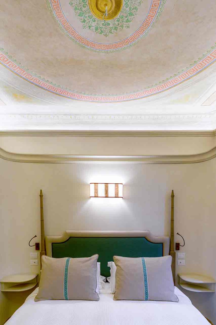 Look up and admire the hand-painted ceiling adorned with intricate frescoes .