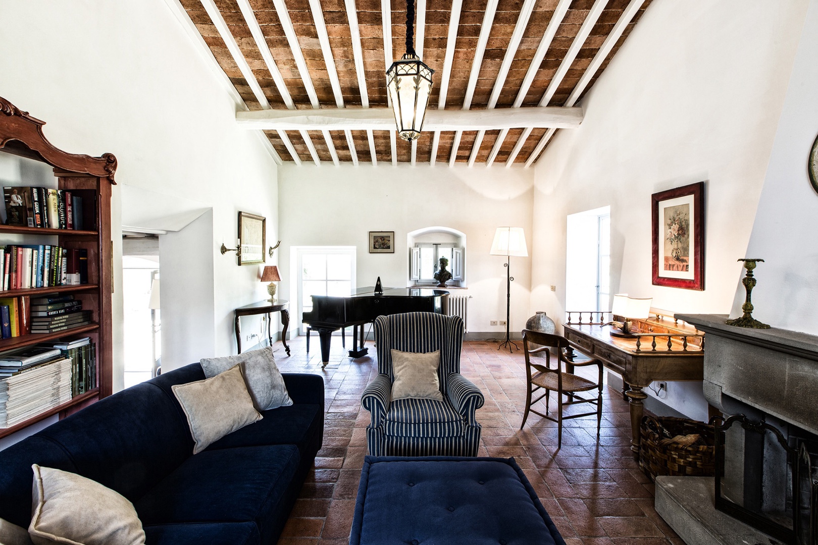 Cottage living room complete with fireplace and grand piano.